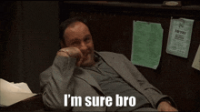 a man in a suit sits in front of a menu that says i 'm sure bro