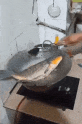 a fish is being cooked in a frying pan on a stove