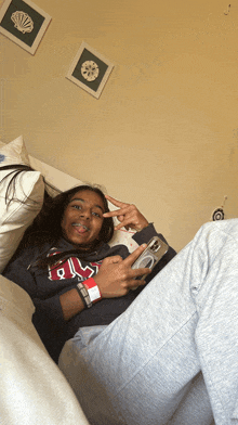 a girl laying on a bed wearing a sweatshirt that says rl