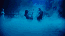 a man in a top hat is playing a violin while a woman in a white dress watches
