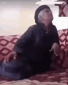 a person is sitting on a couch with their legs crossed and their arms outstretched .