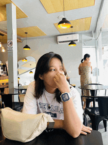 a woman wearing a nevada shirt sitting at a table