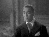 a black and white photo of a man in a suit