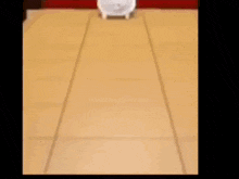 a white piggy bank is sitting on a wooden floor next to a pile of wooden letters .