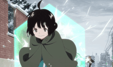 a girl in a green cape is standing in front of a brick building