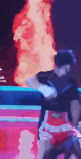 a man is standing in front of a fire in a video game .