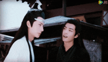 two men are standing next to each other and one of them is wearing a crown on his head