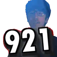 a man with glasses holds up the number 921 in front of his face