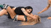 two women are wrestling on a wrestling mat with the letters n on the bottom right