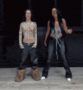 two women are standing next to each other and dancing in front of a building .