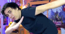 a man in a black shirt is stretching his arms in front of a wall with posters of mario and luigi on it