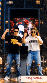 a man and a woman are dancing in front of a billboard that says d.k. & sahara