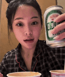 a woman in a plaid shirt is holding a can of beer that says beer