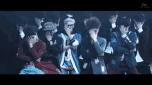 a group of people are kneeling down in a dark room with sm written in the corner