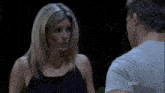 a man and a woman are talking to each other in a dark room .