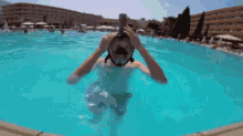 a person wearing a mask is swimming in a pool .