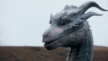 a dragon with horns is looking at the camera