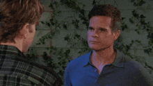 a man in a plaid shirt stands next to another man