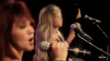 a woman singing into a microphone with rbd.gif written on the bottom right