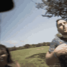 a man and a woman are standing in a field