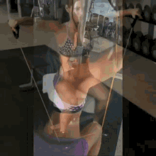 a woman in a bikini is doing exercises on a machine