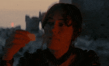 a close up of a woman 's face in front of a sunset