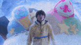a man in a yellow hoodie stands in front of a display of ice cream