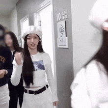 a woman wearing a white hat is standing in a hallway with a sign that says 10 on it