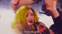 a woman with yellow hair is singing and says i love you too .