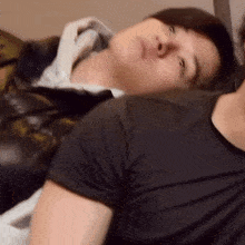 a man in a black shirt is laying on another man 's chest