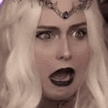 a close up of a woman 's face with a tiara on her head .
