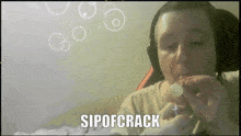 a man wearing headphones is holding a bubble with the words sipofcrack written below him
