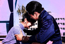 a man in a blue jacket is hugging a woman