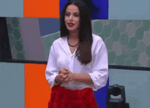 the woman is wearing a white shirt and a red skirt .