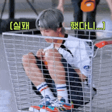 a man is sitting in a shopping cart with korean writing on the bottom