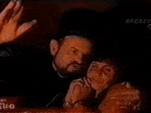 a man and a woman are standing next to each other in a dark room and looking at each other .