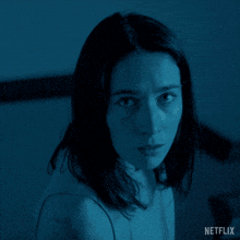 a woman is looking at the camera with a netflix logo behind her