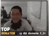 a man wearing headphones is smiling in front of a sign that says " top donator "