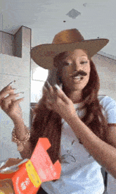 a woman wearing a cowboy hat and a fake mustache is holding a box of potato chips