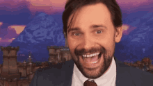 a man in a suit and tie is laughing with his mouth open