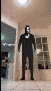 a man in a black suit is standing in a hallway with a viggle.ai logo on the bottom