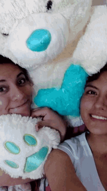 a woman holding a stuffed animal with a blue heart on it