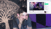 a man sitting in front of a microphone in front of a screen that says youtube on it