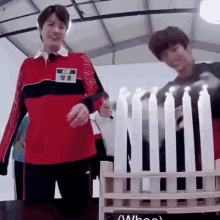 two young men are playing a game with candles .