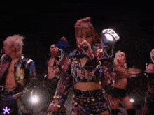 a woman singing into a microphone in front of a group of men