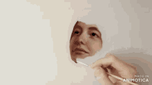 a person is painting a face with a brush that says made in animatica on the bottom