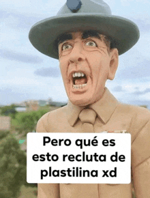 a statue of a man in a military uniform has a sign that says pero que es esto recluta de plastilina xd