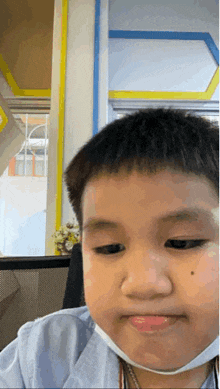 a young boy with a mask on his face looks at the camera