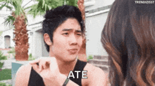 a man is making a funny face while talking to a woman and says `` ate '' .