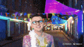 a man wearing glasses and a sequined jacket is smiling in front of a banner that says minimx